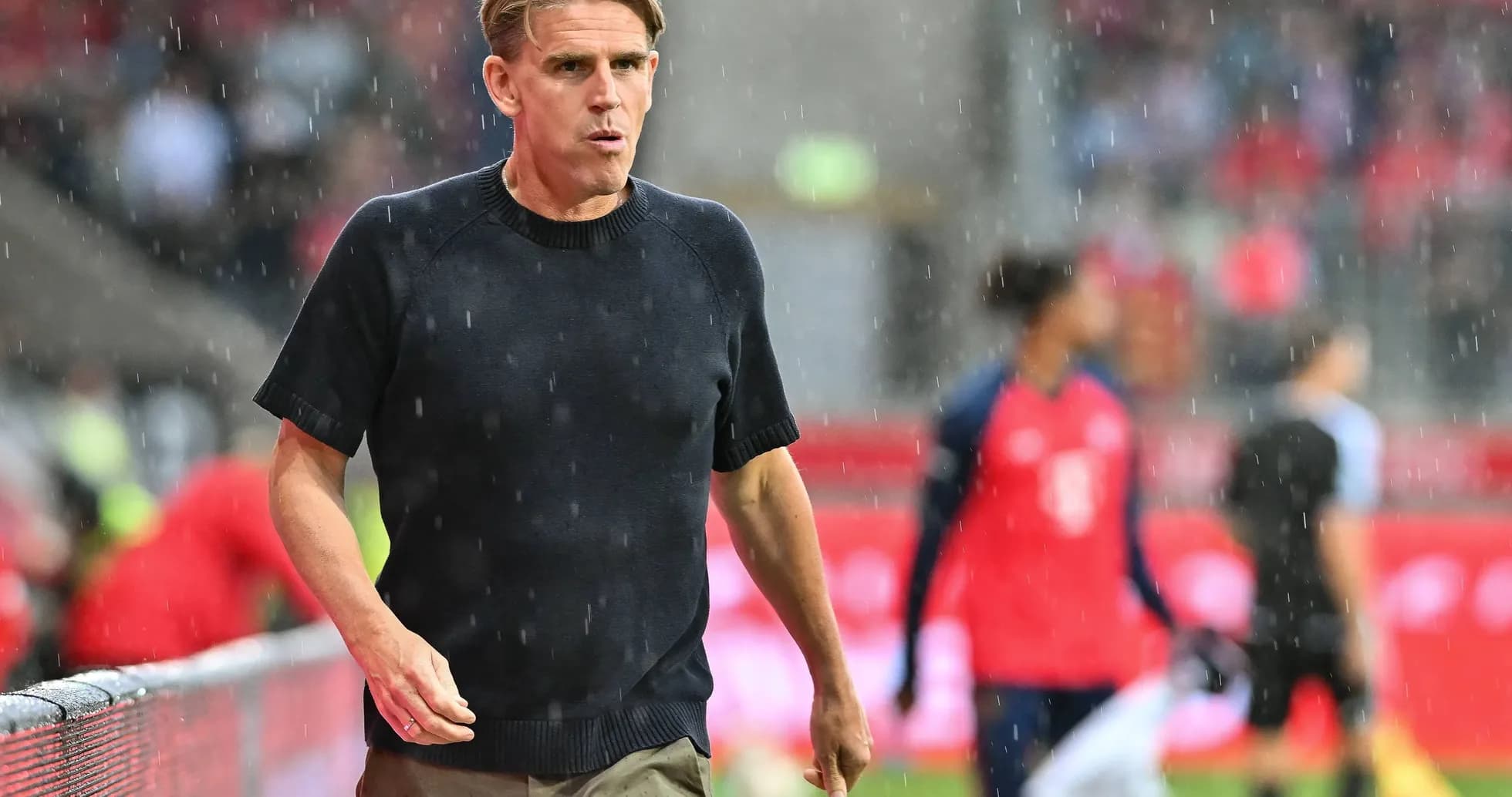 Coach walking on the sideline during rain