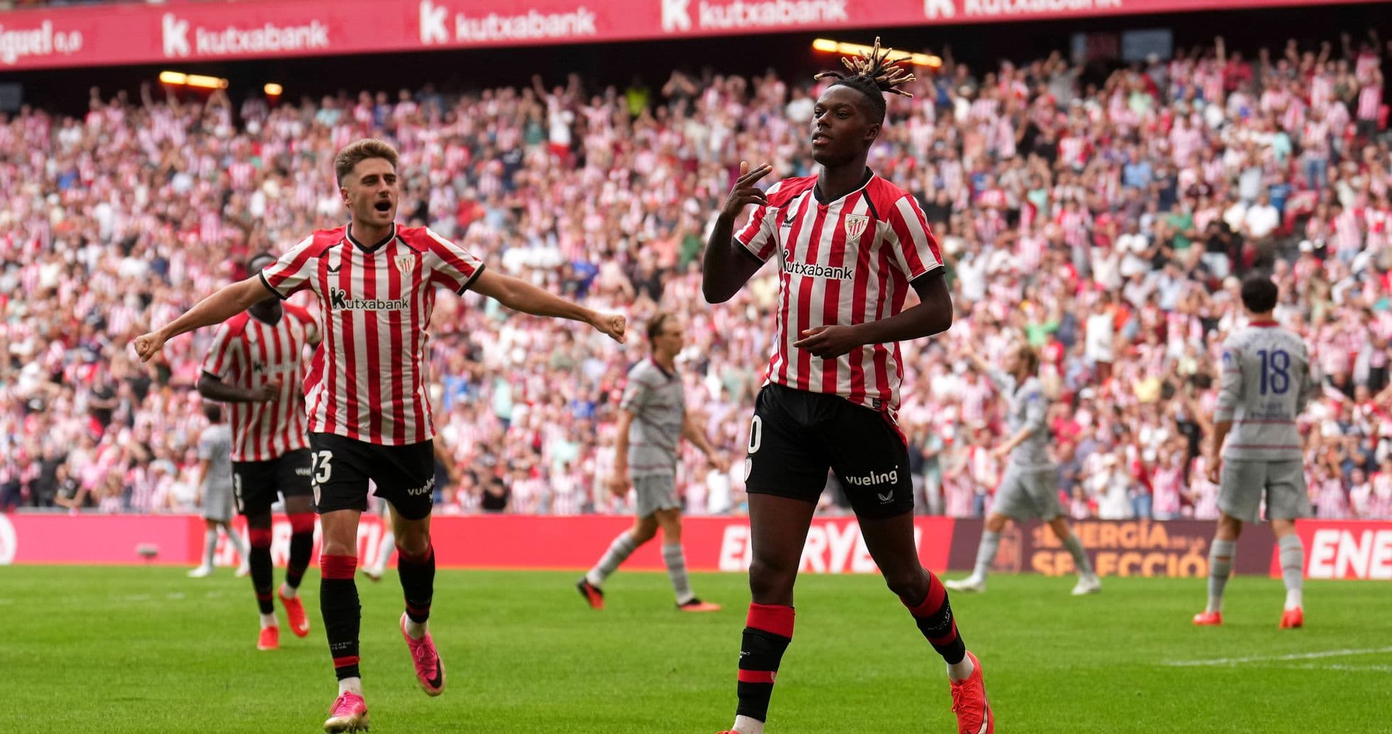 Player celebrating goal with teammates in stadium