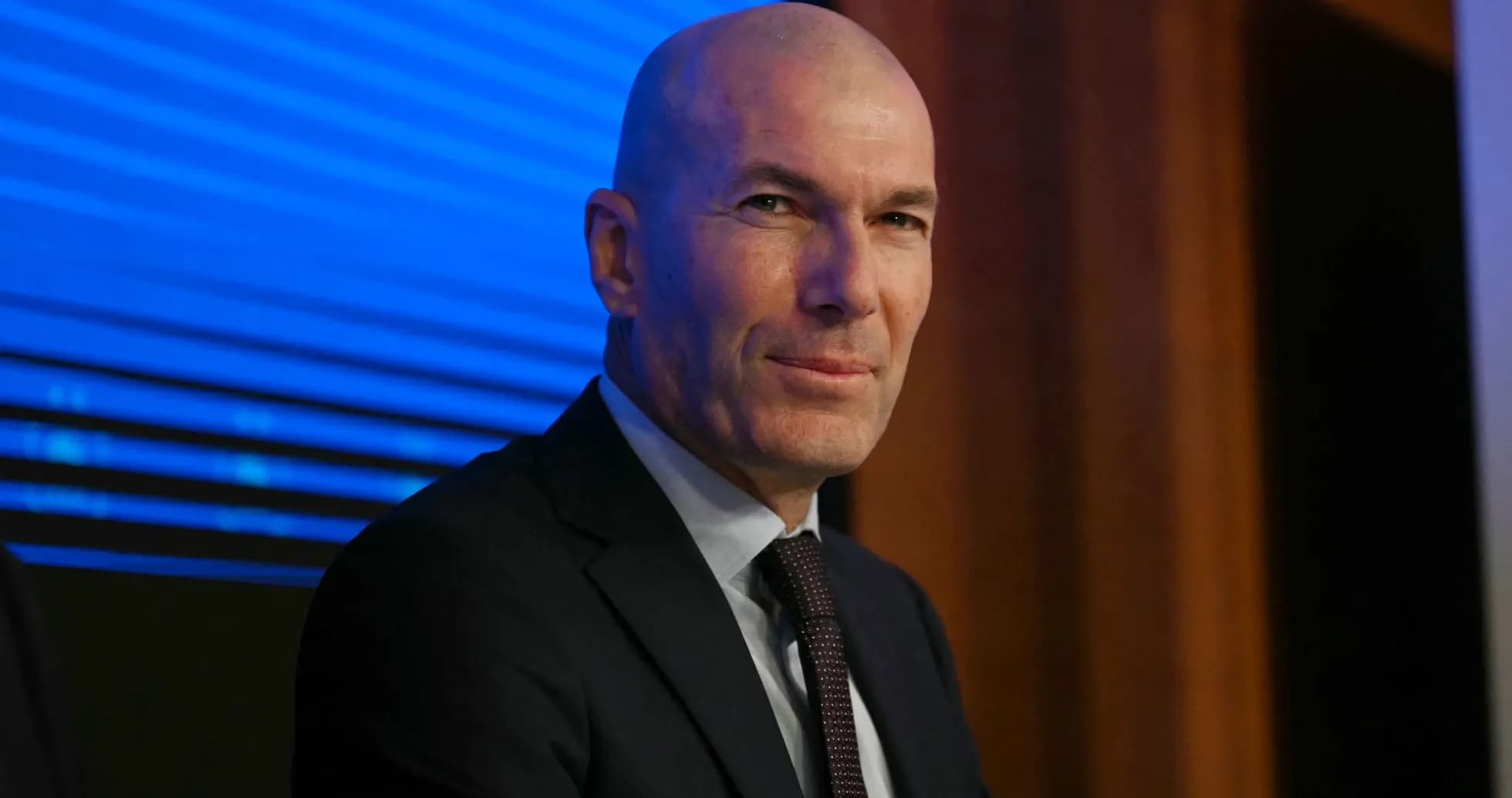 Man in suit sitting at a press conference