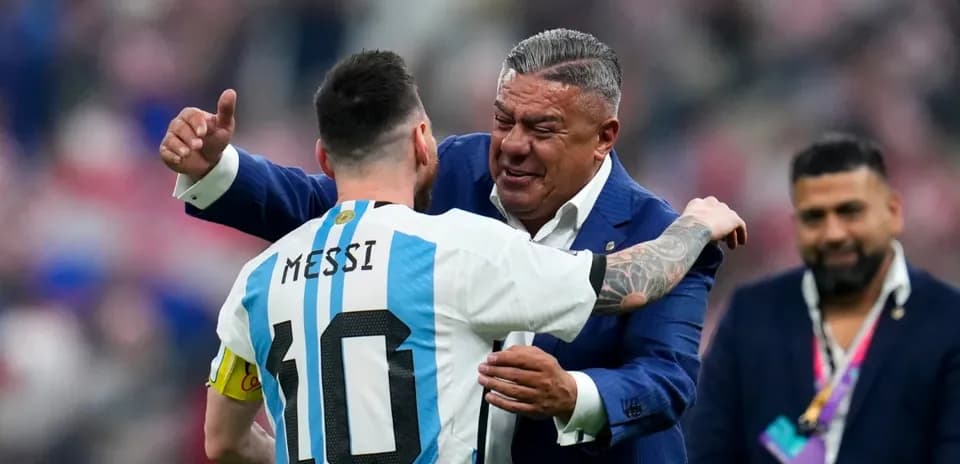 Lionel Messi embracing a man in a suit