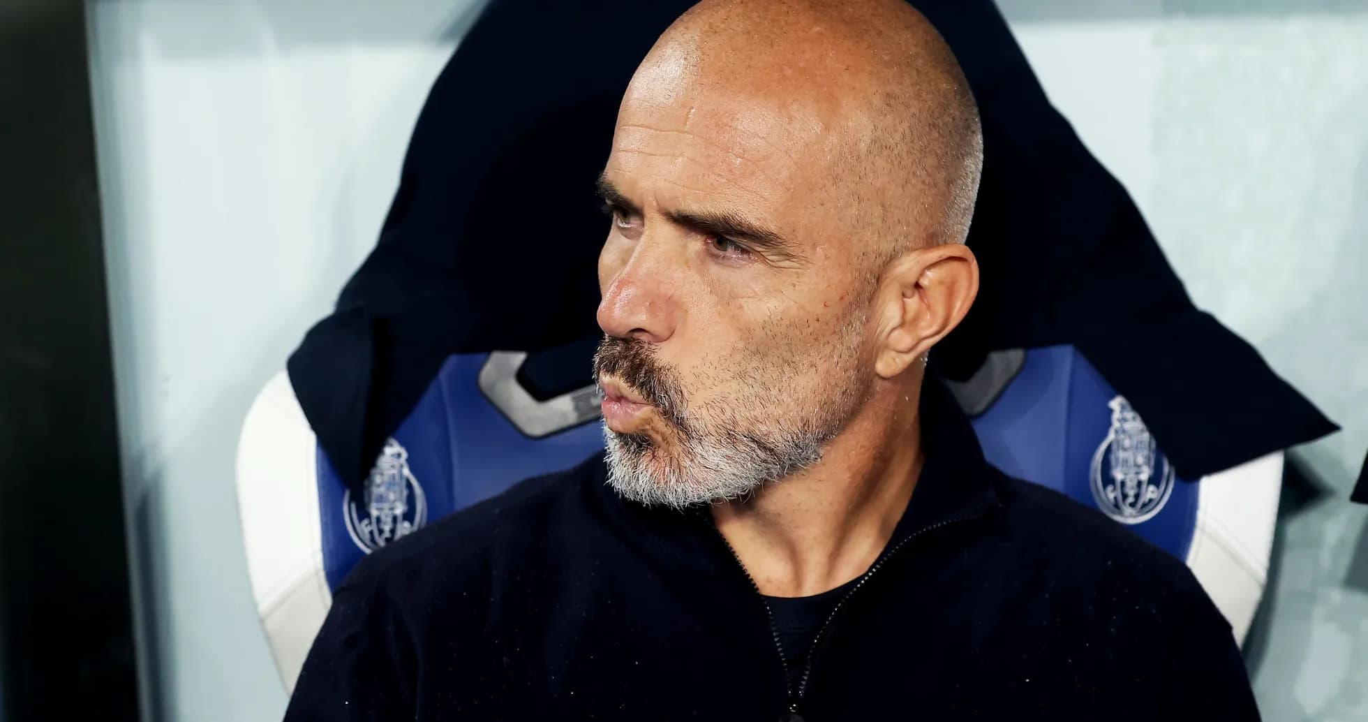 Coach seated on bench during a match