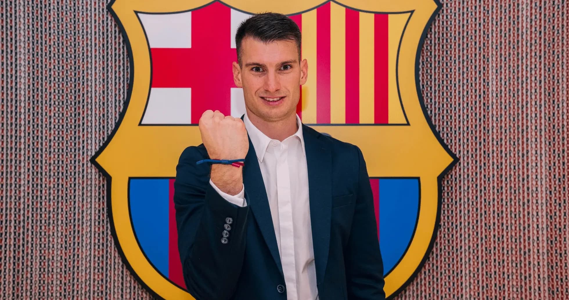 Player showing fist with Barcelona logo backdrop