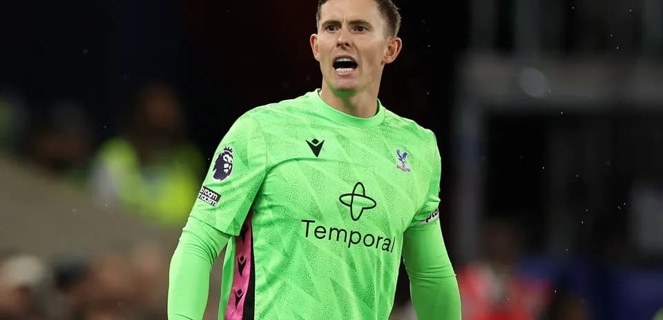 Goalkeeper in green jersey directing players on field