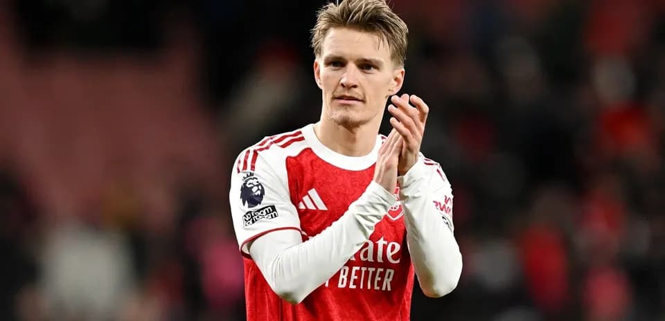 Player applauding fans after match wearing Arsenal jersey