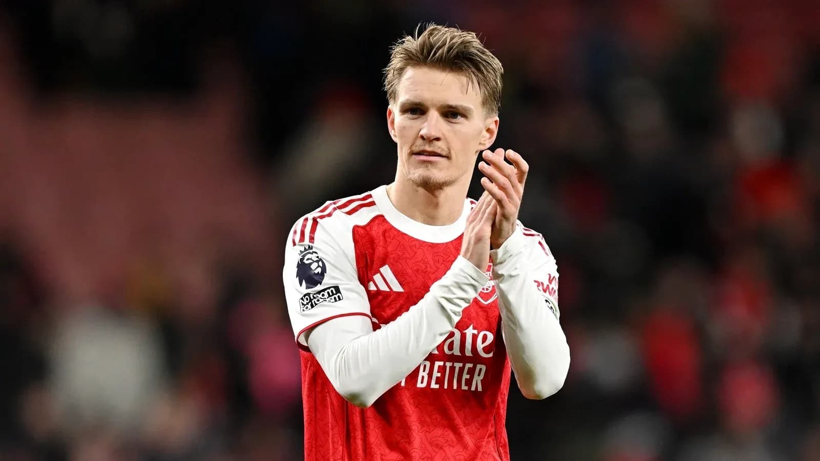 Player applauding fans after match wearing Arsenal jersey