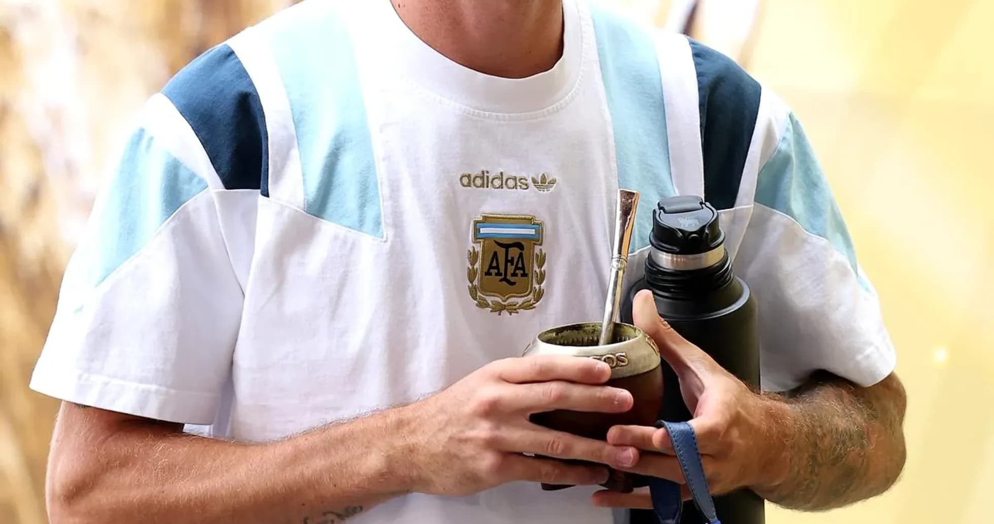 Player holding mate cup and water bottle