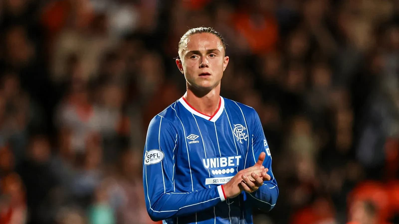 Player applauding fans while wearing Rangers jersey