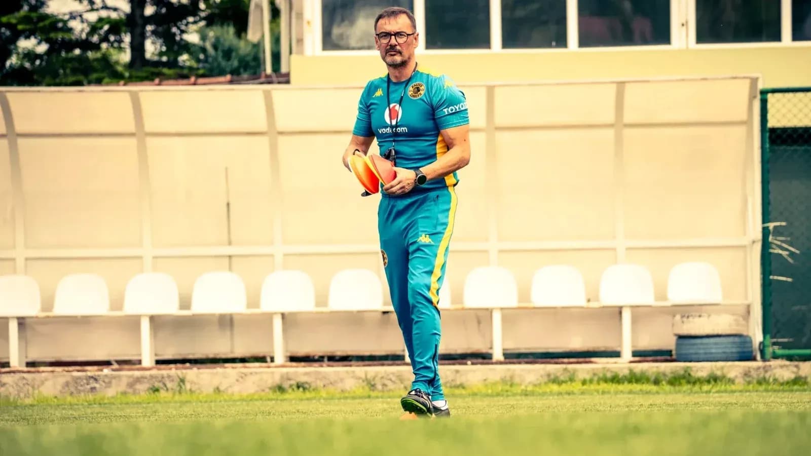 Coach holding training cones on football field