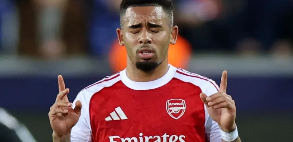 Player with Arsenal jersey holding hands up in prayer