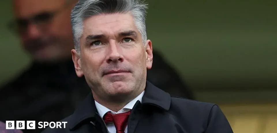 Man in suit observing from the stands