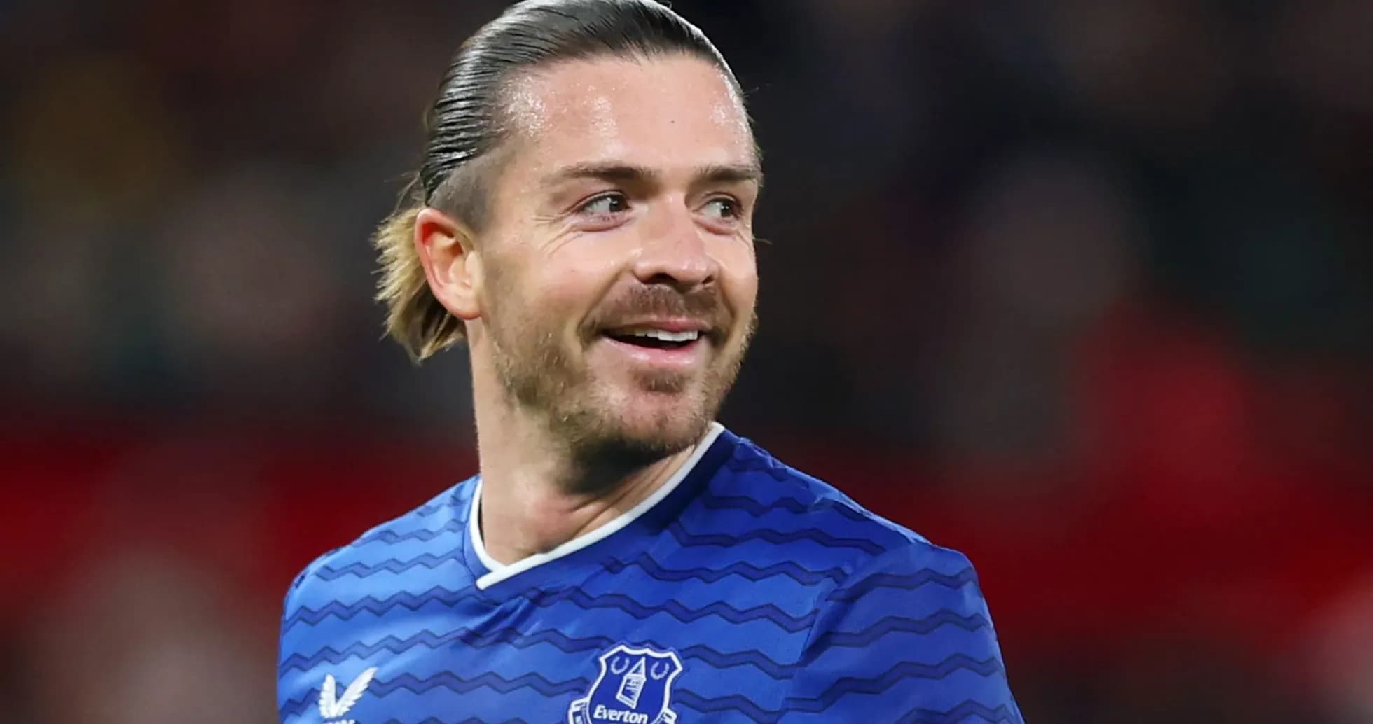 Football player smiling in Everton jersey during match