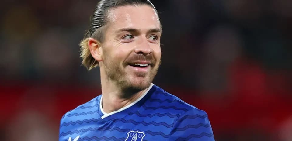 Football player smiling in Everton jersey during match