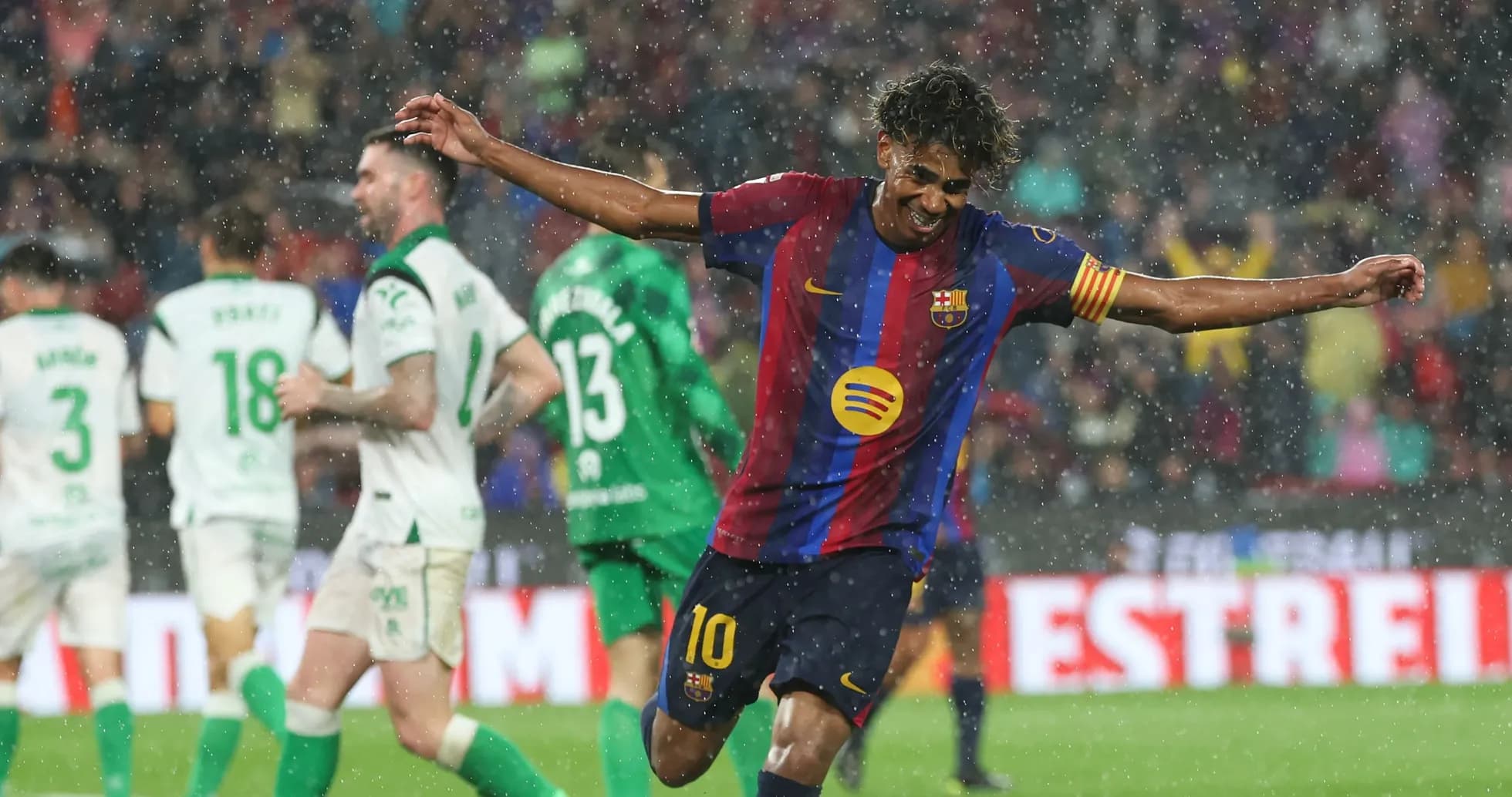 Player celebrating a goal during rainy match