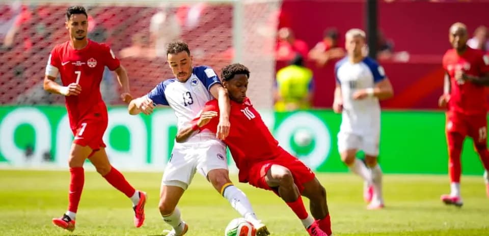 Canada player tackling Bosnia player during match
