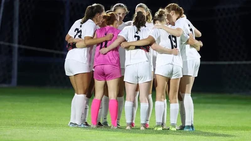 Soccer team huddling together before the match