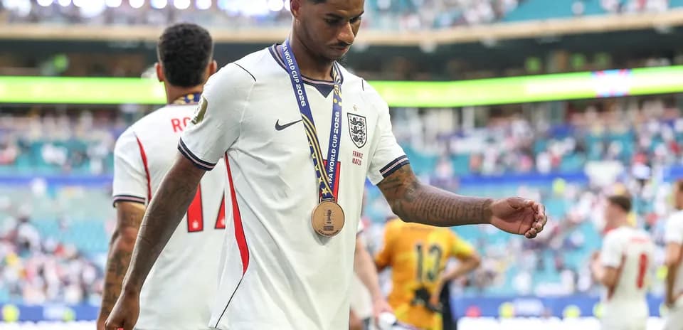 Player walking off field wearing a bronze medal