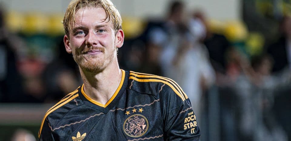 Player in Ajax jersey smiling at the camera