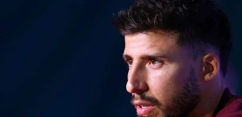Player speaking at press conference with serious expression