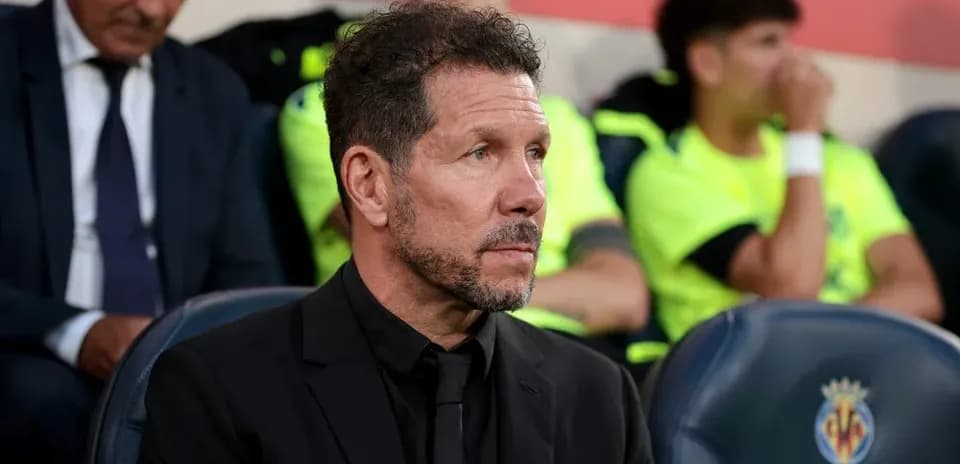 Coach seated on bench during match at stadium