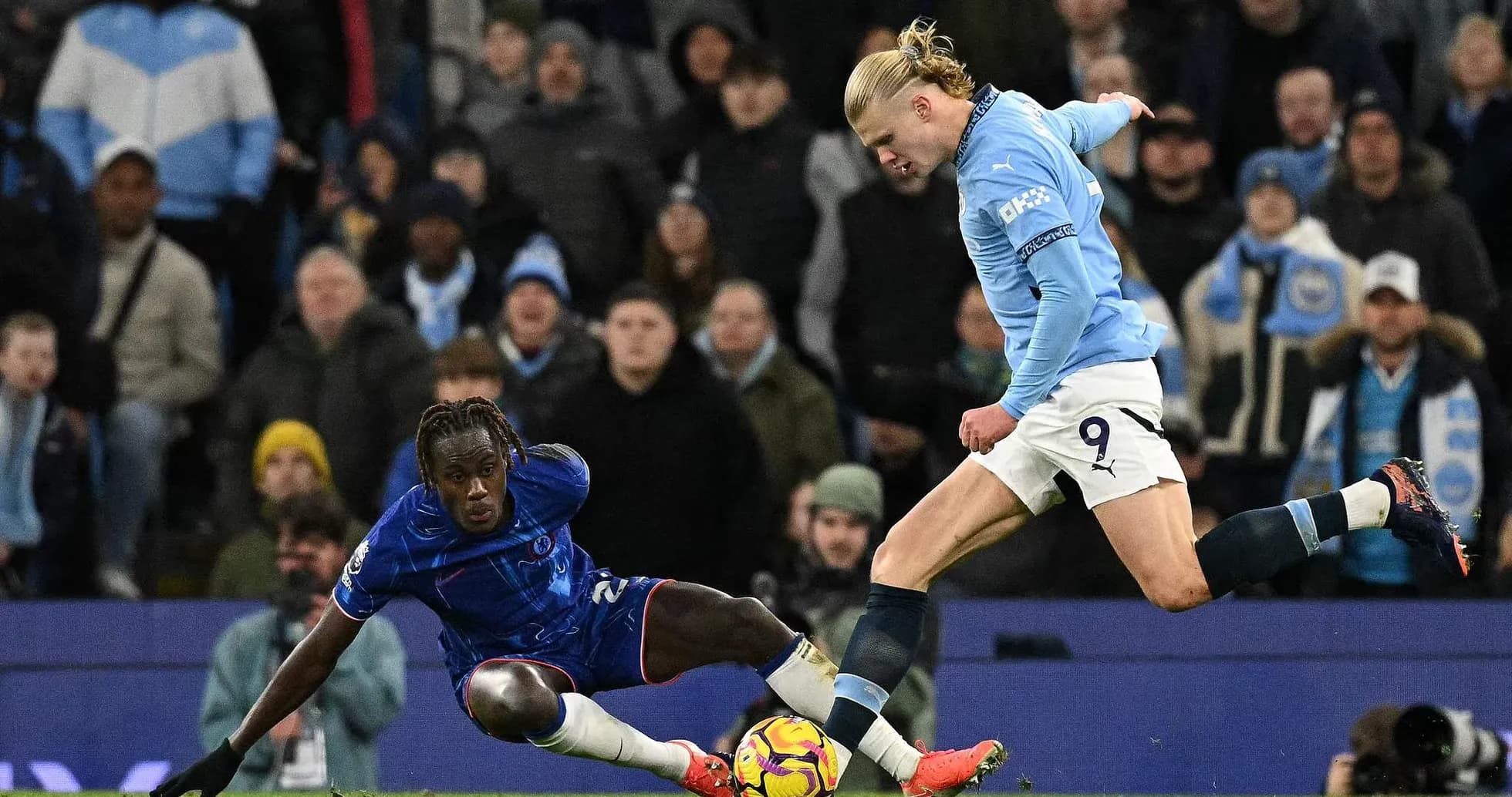 Chelsea player tackling Manchester City striker