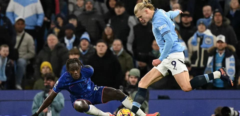 Chelsea player tackling Manchester City striker