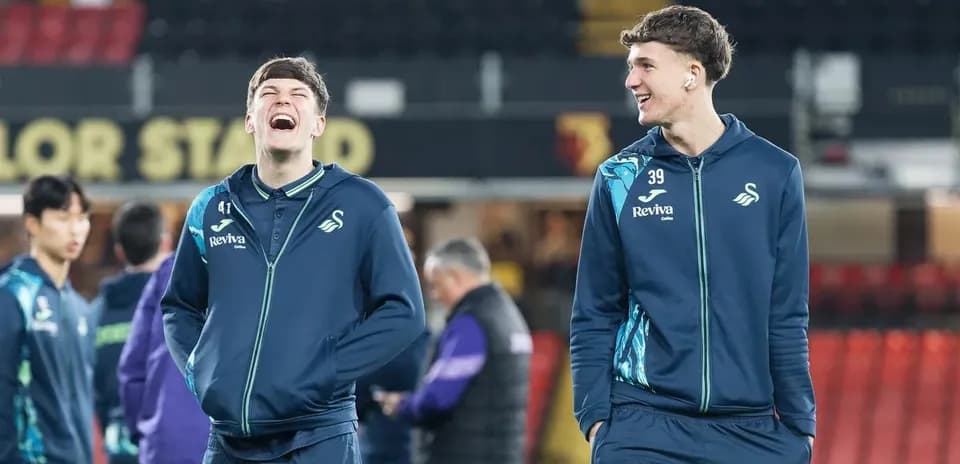 Two Swansea City players laughing during warm-up