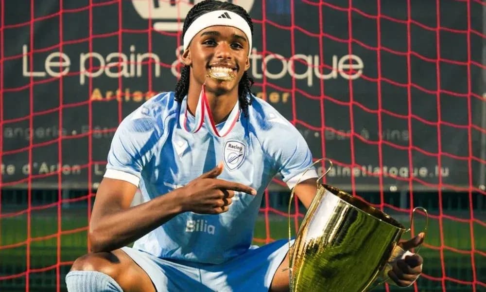 Player celebrating with trophy in front of goal