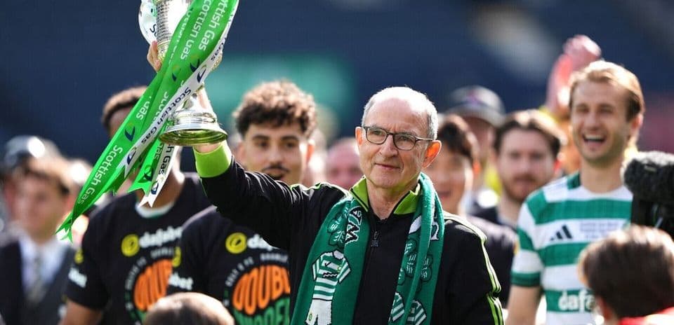 Coach celebrating with trophy and team members