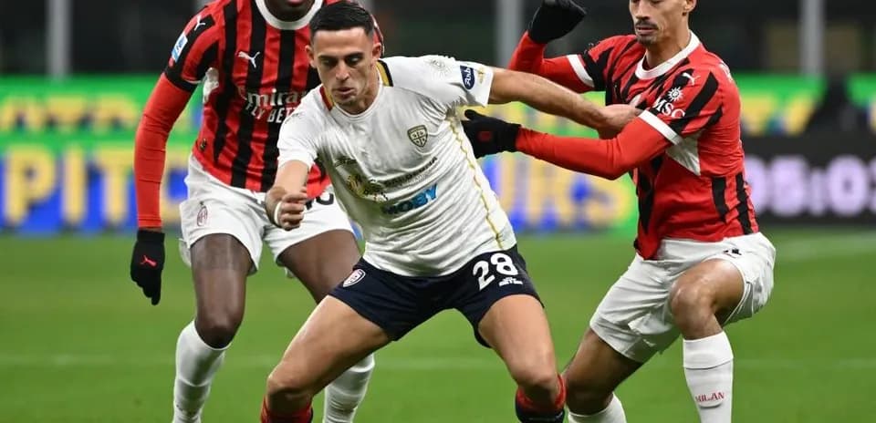 AC Milan players challenging Cagliari midfielder