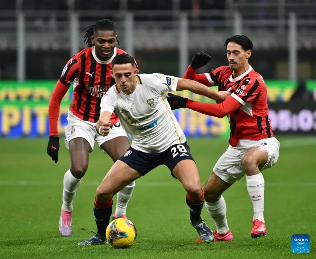 AC Milan players challenging Cagliari midfielder