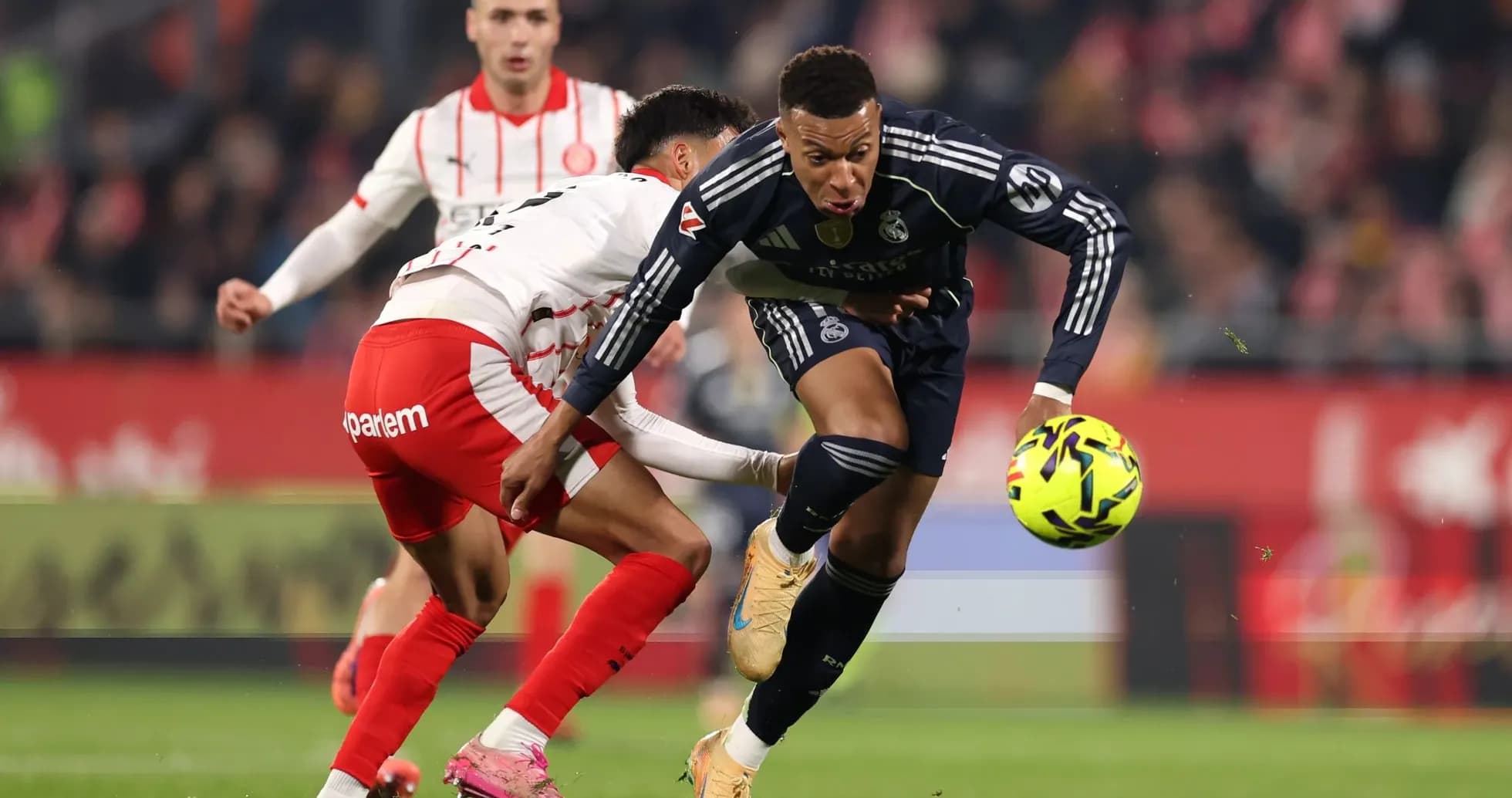 Real Madrid player dribbling against Girona defender