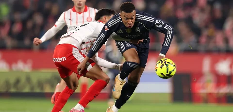 Real Madrid player dribbling against Girona defender