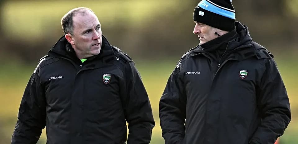Two coaches discussing strategies during training session