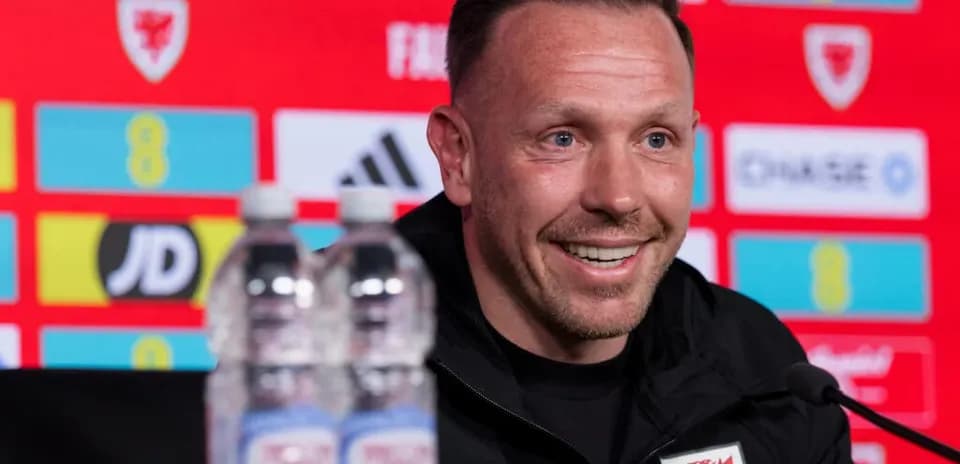Manager speaking at press conference with water bottles