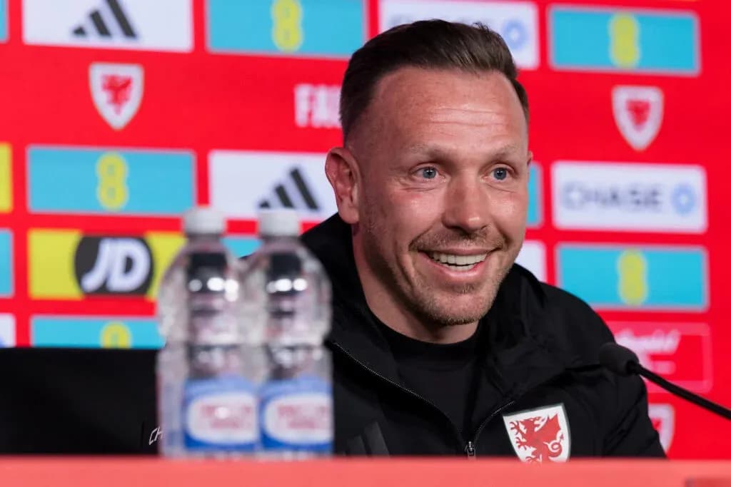 Manager speaking at press conference with water bottles