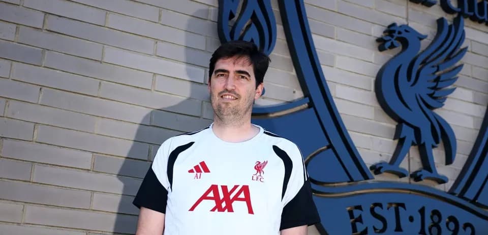 Coach in Liverpool FC training gear by club logo