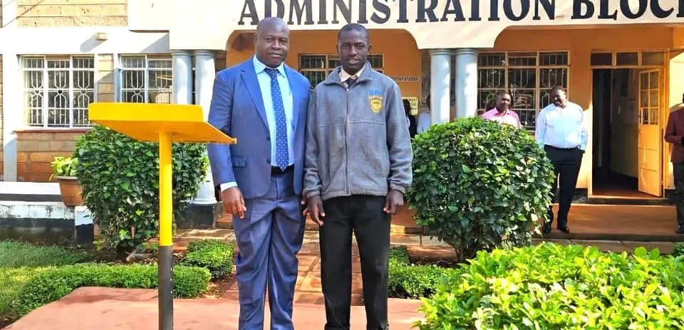 Two men posing outside St. Anthony's Boys' High School