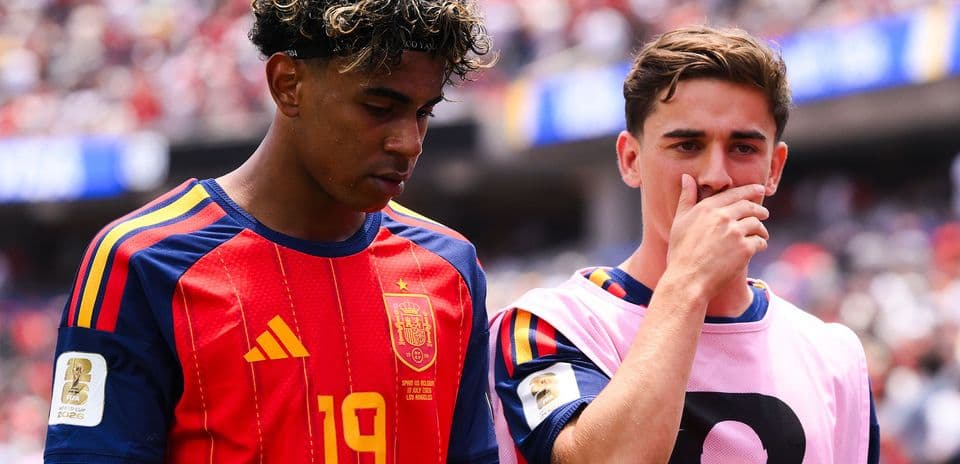 Two Spanish players on the sidelines during match