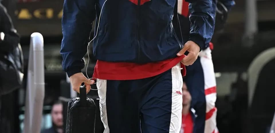 Player in tracksuit arriving at venue with bag