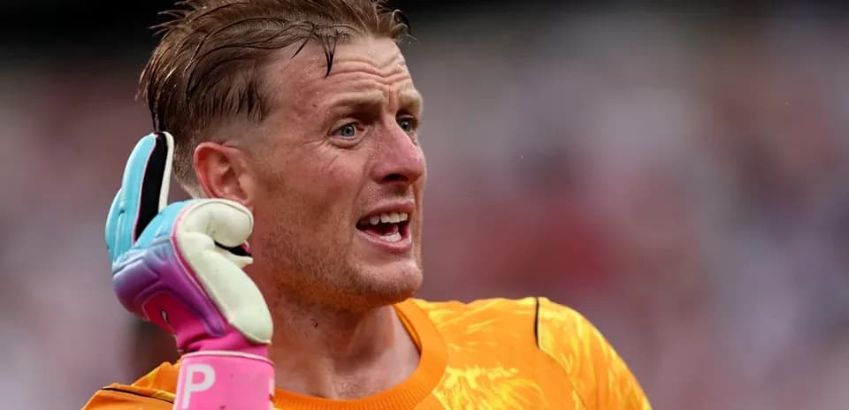 Goalkeeper gesturing during match with colorful gloves