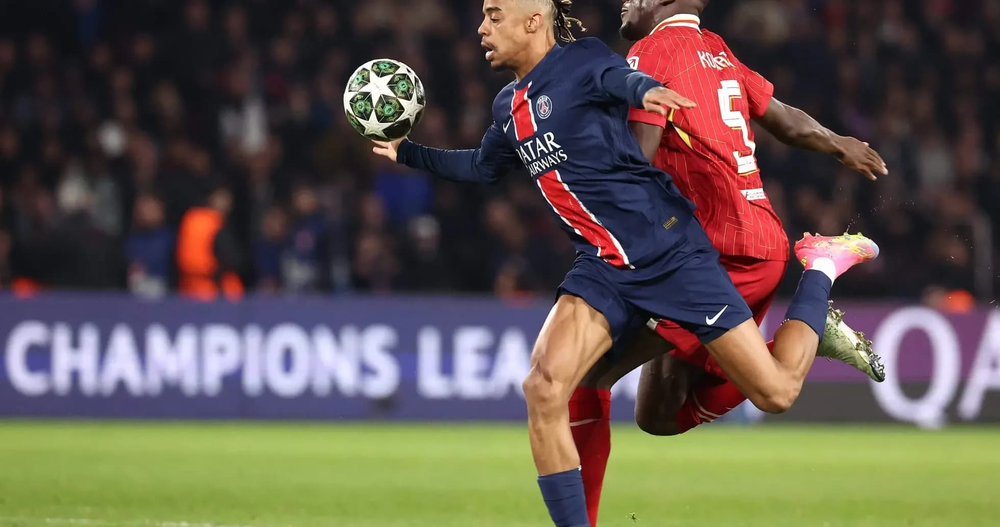 PSG player dribbling past Liverpool defender