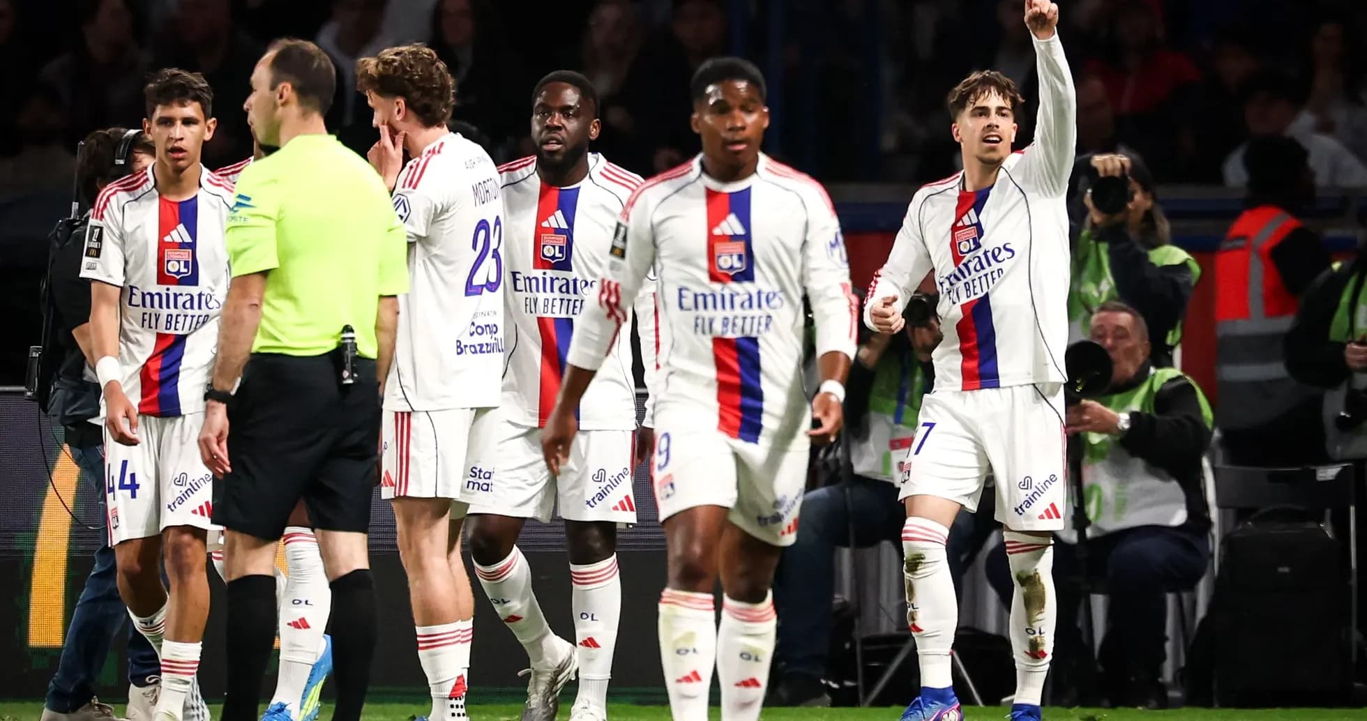Lyon players interacting with referee during match