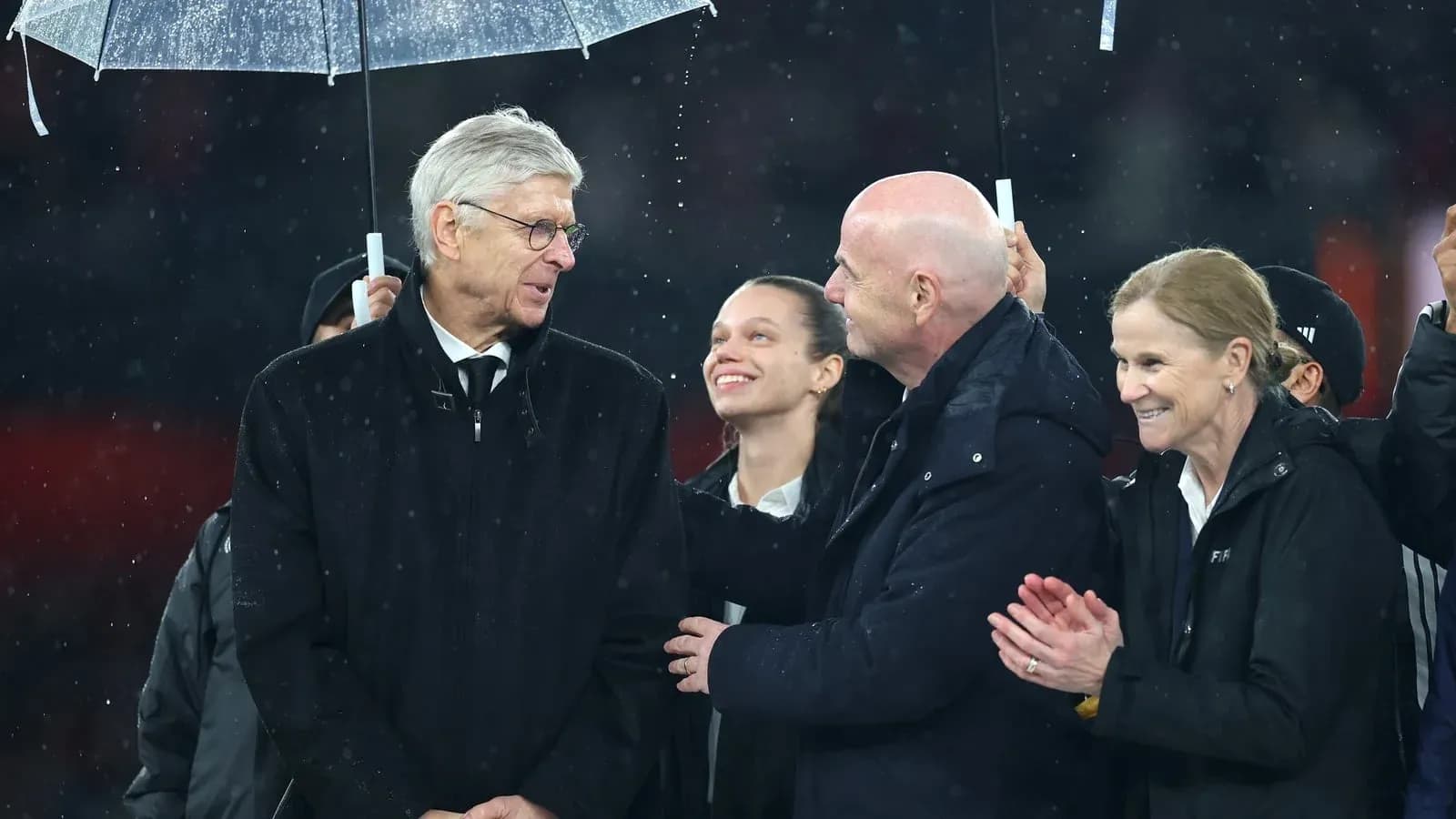 Group of officials talking under an umbrella