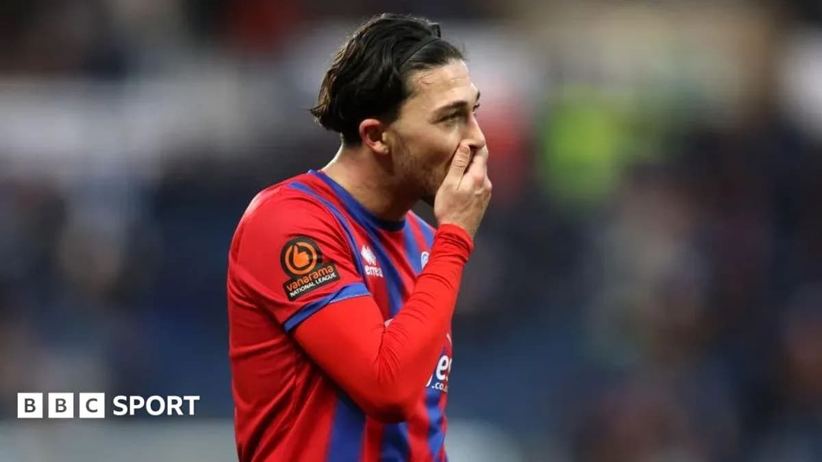 Player in red and blue kit touching his face