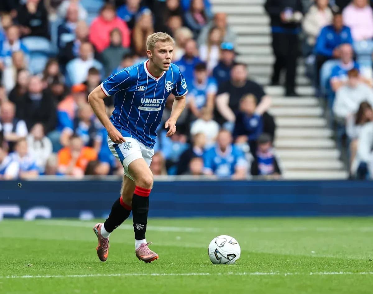 Rangers player running with ball on pitch
