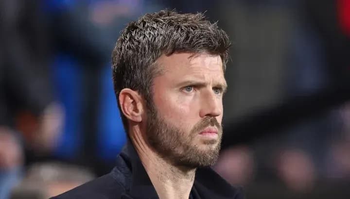 Man in black coat observing a football match
