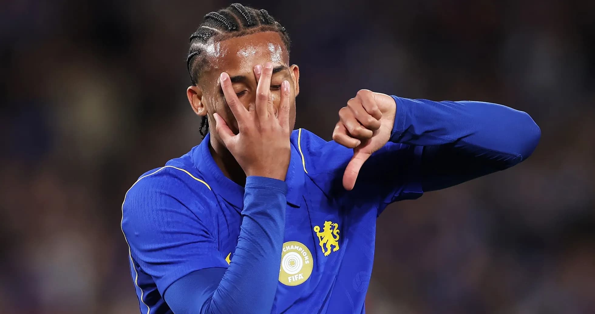 Player in blue jersey showing a thumbs down gesture