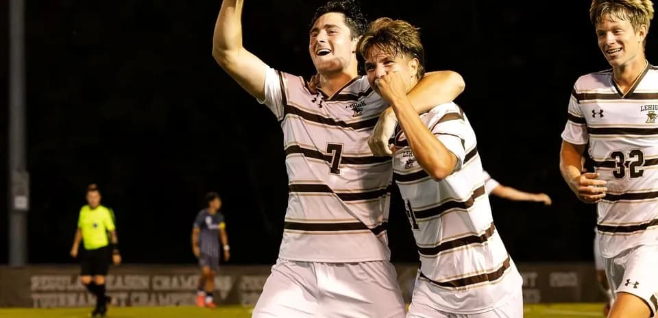 Players celebrating a goal on the soccer field