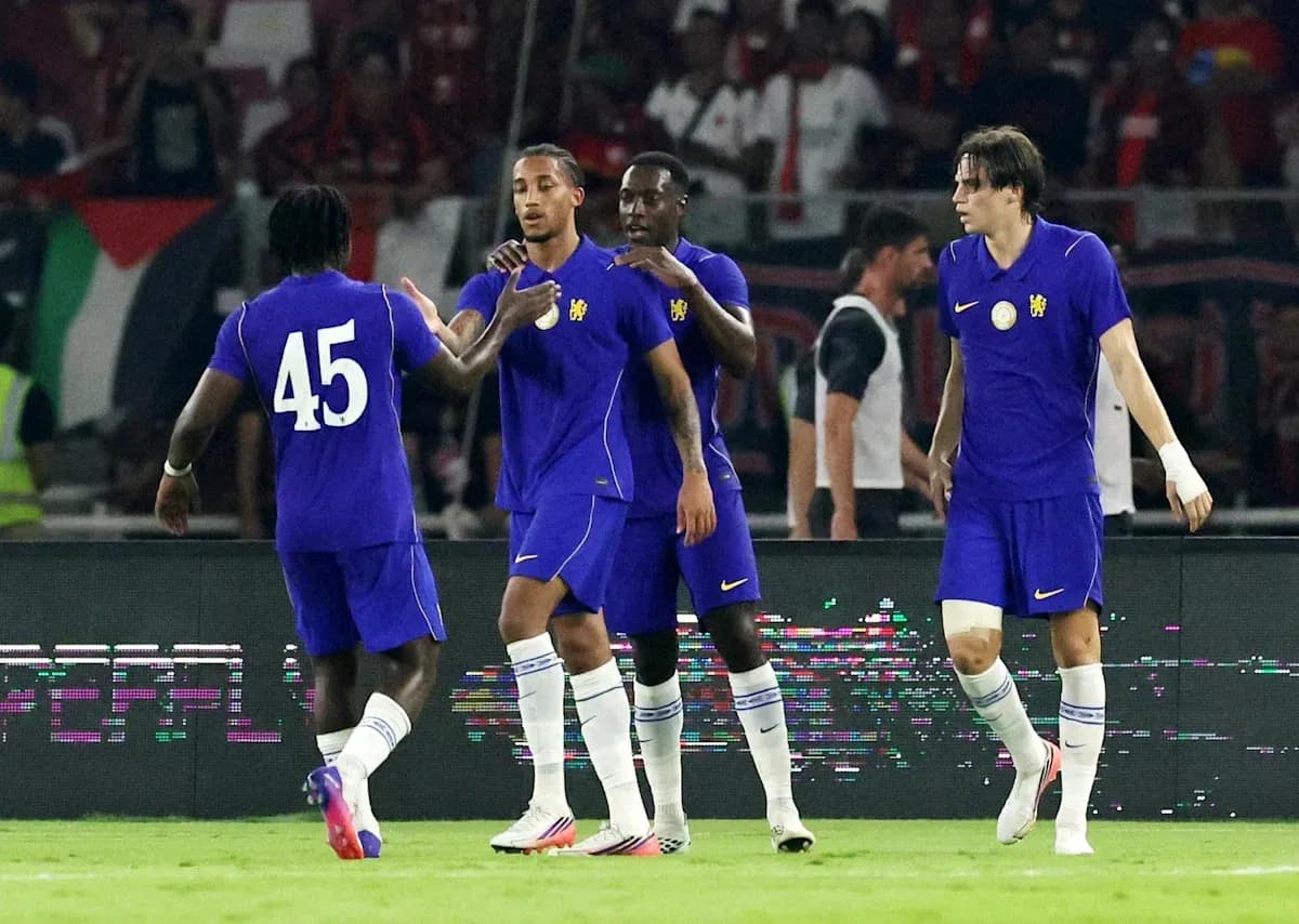 Four players in purple jerseys celebrating on field