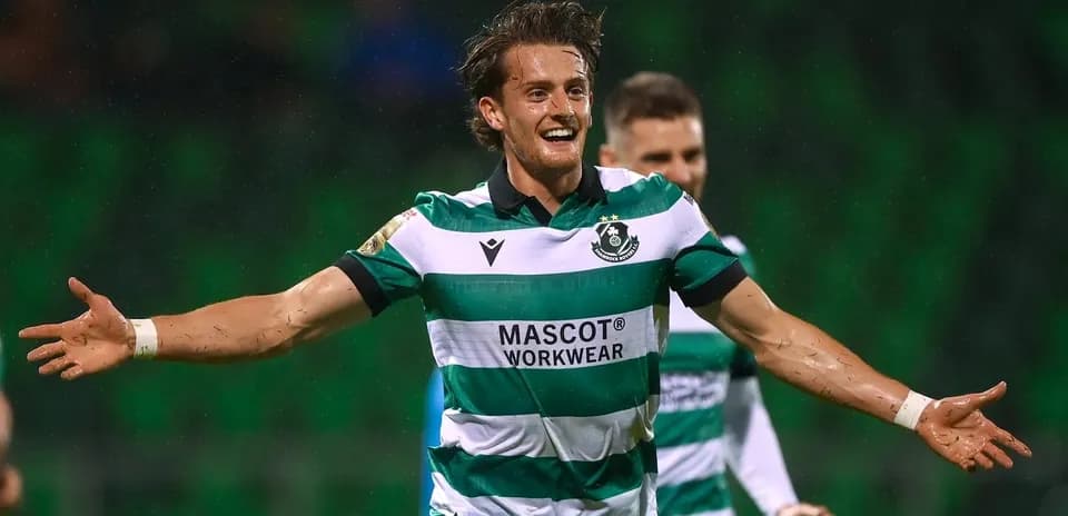 Player celebrating a goal in green and white uniform